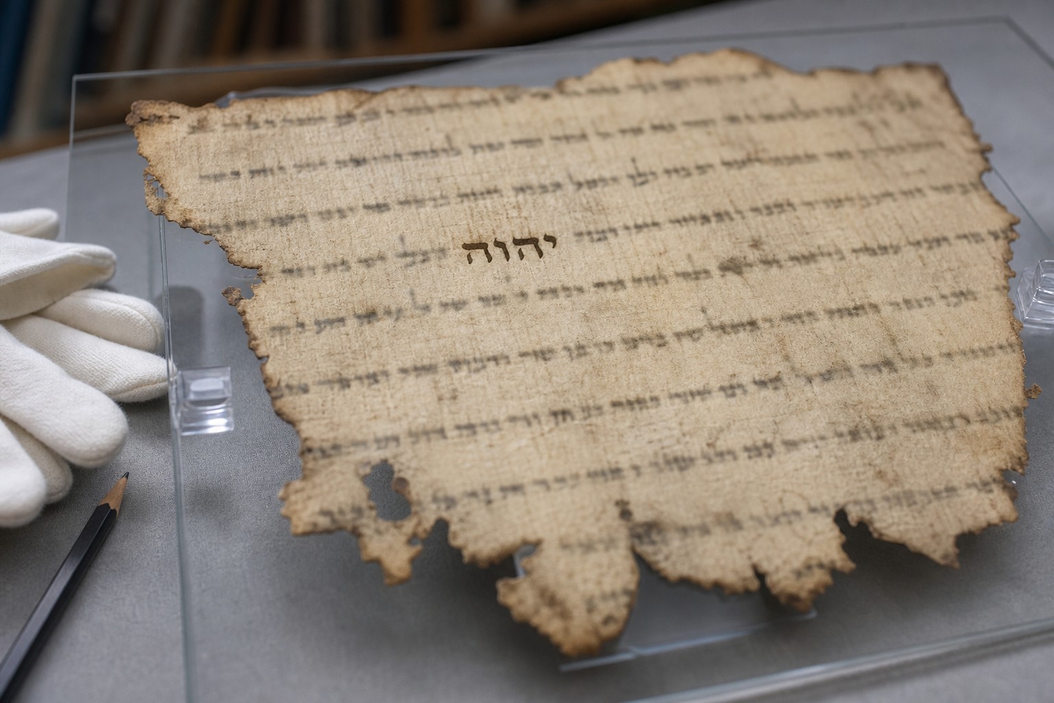 Illustration of the Hebrew Tetragrammaton on a manuscript fragment in a conservation setting